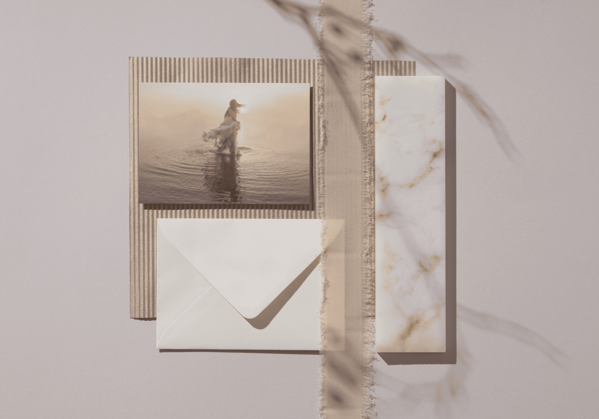 Flat lay of cards, envelope, and marble-patterned paper on neutral background.