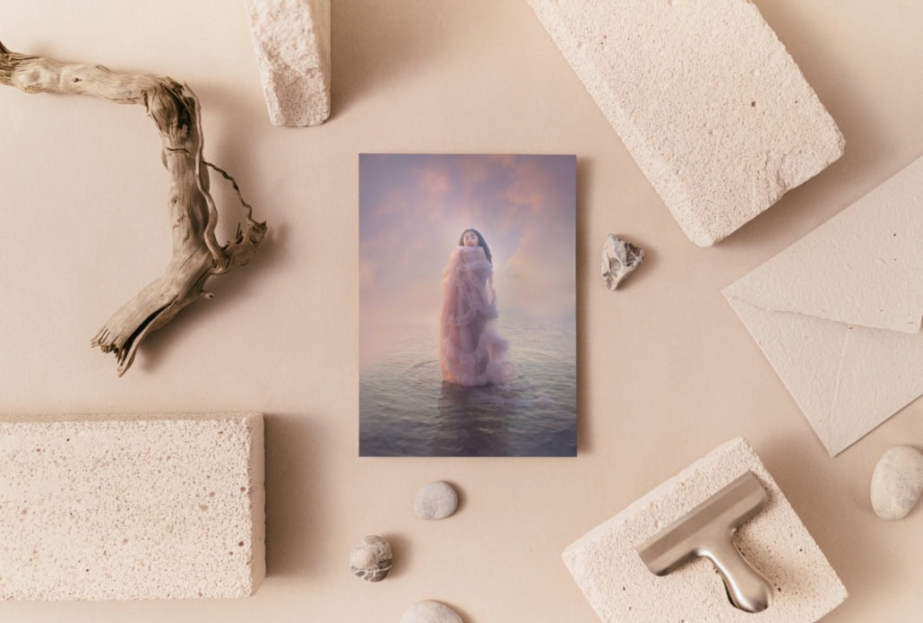 Cards are available in the Louisa Peacock online shop Surreal artwork of a woman in water with a cloudy sky background.